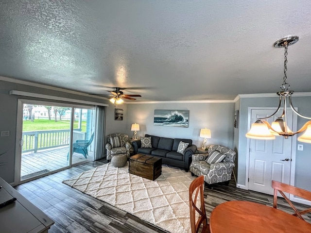 living area with ornamental molding, a textured ceiling, a ceiling fan, and wood finished floors