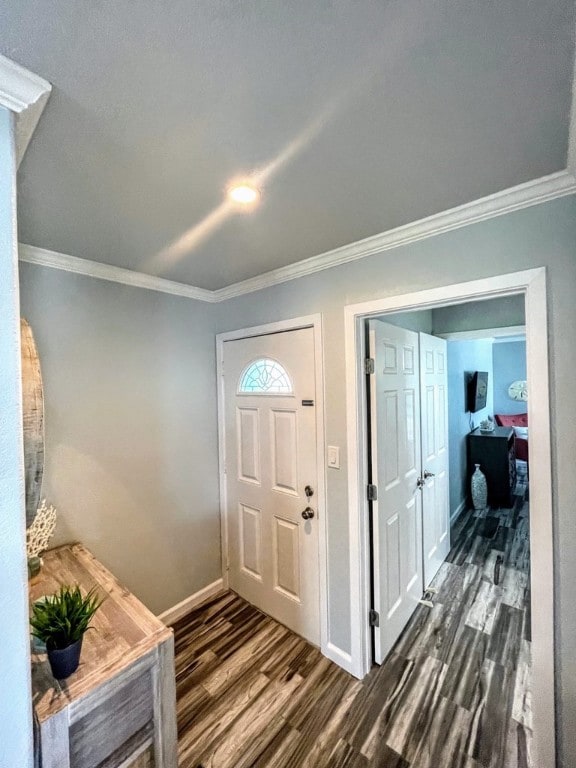 foyer entrance with dark wood-style floors, baseboards, and crown molding