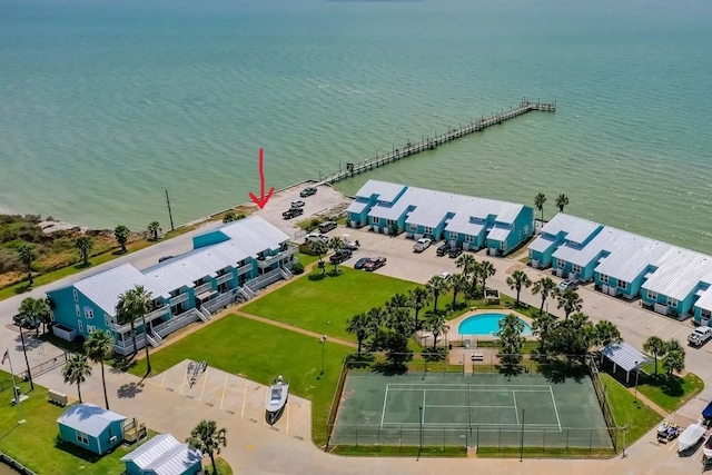 drone / aerial view of a nearby body of water and a pool area