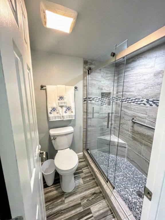 bathroom featuring toilet and a shower stall