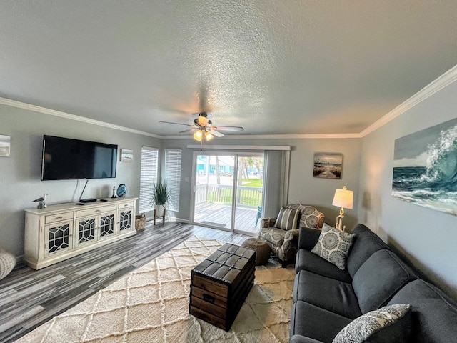 living area featuring crown molding, ceiling fan, wood finished floors, and baseboards