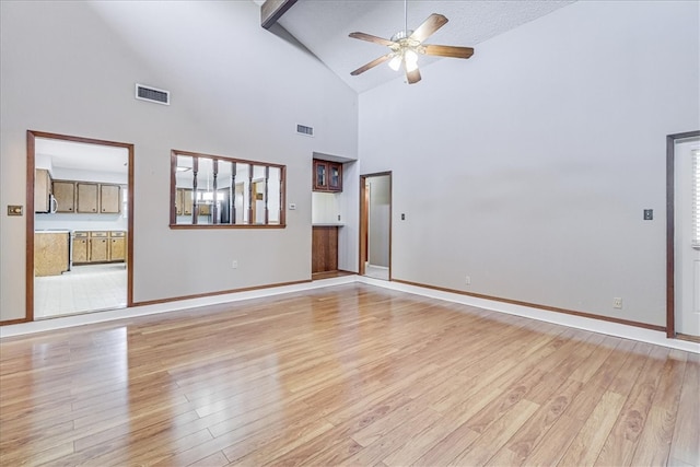 spare room with high vaulted ceiling, beamed ceiling, ceiling fan, and light hardwood / wood-style flooring