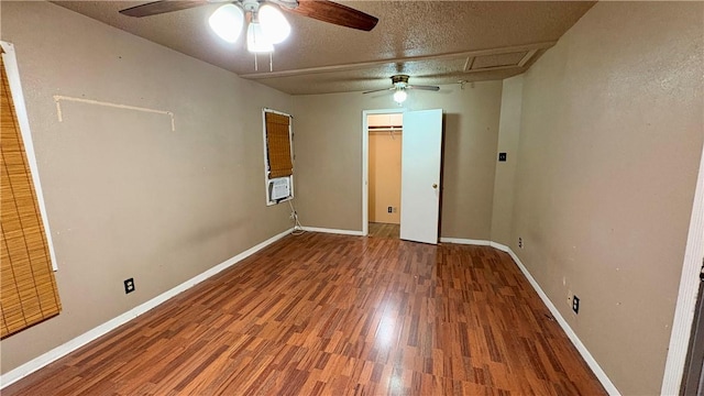 unfurnished room with a ceiling fan, wood finished floors, baseboards, and a textured ceiling