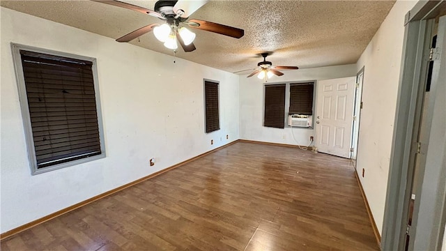 spare room with wood finished floors, ceiling fan, baseboards, a textured ceiling, and cooling unit
