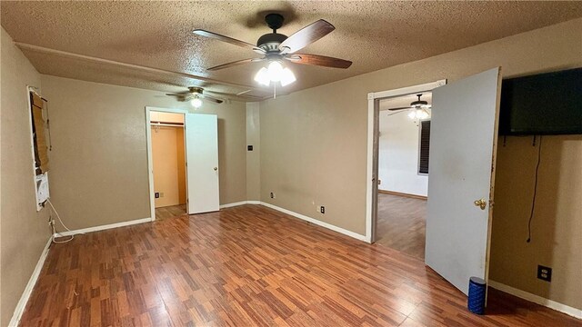 unfurnished bedroom featuring wood finished floors, a textured ceiling, ceiling fan, and baseboards