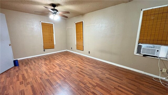 spare room featuring wood finished floors, ceiling fan, a textured ceiling, baseboards, and cooling unit