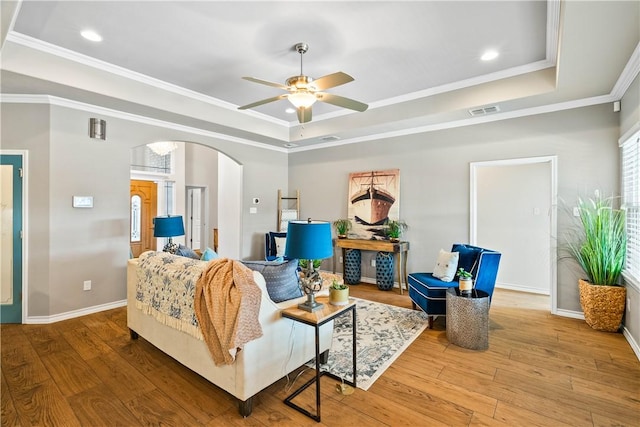 2718 Yeager Dr, Corpus Christi, TX 78410 - living room with a tray ceiling, arched walkways, ceiling fan, ornamental molding, and wood finished floors