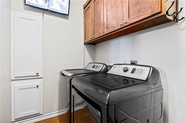 2718 Yeager Dr, Corpus Christi, TX 78410 - washroom featuring washing machine and clothes dryer, cabinet space, and wood finished floors