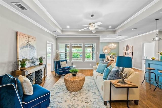 2718 Yeager Dr, Corpus Christi, TX 78410 - living room with a tray ceiling, wood-type flooring, ceiling fan, a chandelier, and ornamental molding