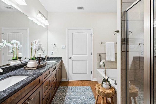 2718 Yeager Dr, Corpus Christi, TX 78410 - full bath featuring double vanity, a shower stall, a garden tub, and wood finished floors