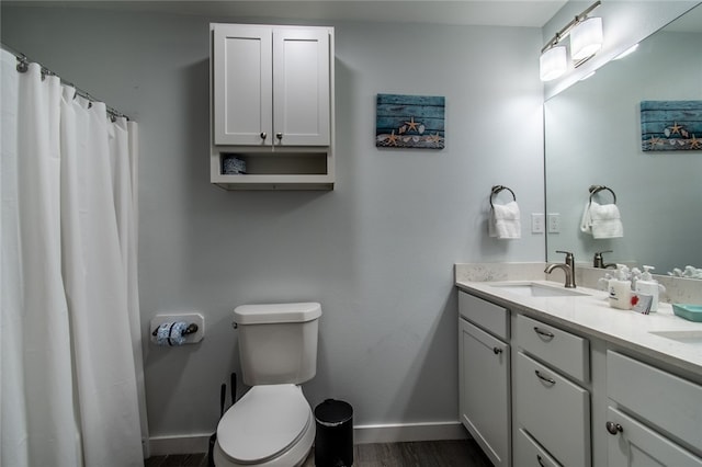 bathroom with wood-type flooring, toilet, and vanity