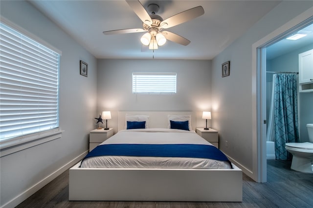 bedroom with dark wood-type flooring, ceiling fan, and connected bathroom