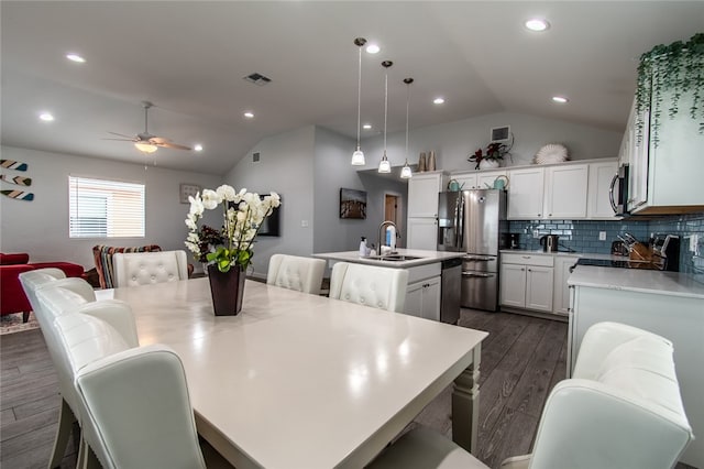 dining area featuring dark hardwood / wood-style flooring, lofted ceiling, sink, and ceiling fan