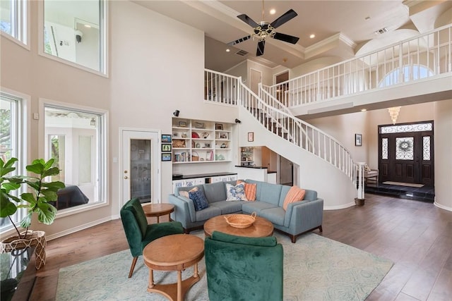 8018 Saint Laurent Dr, Corpus Christi, TX 78414 - living area featuring a towering ceiling, stairway, ornamental molding, wood finished floors, and baseboards
