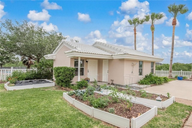 8018 Saint Laurent Dr, Corpus Christi, TX 78414 - view of front of property with a vegetable garden, stucco siding, and a tiled roof