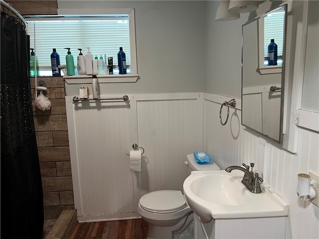 bathroom with hardwood / wood-style floors, curtained shower, and toilet