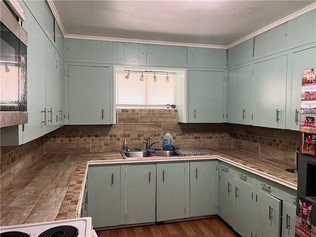 kitchen with sink, dark hardwood / wood-style floors, range, crown molding, and decorative backsplash