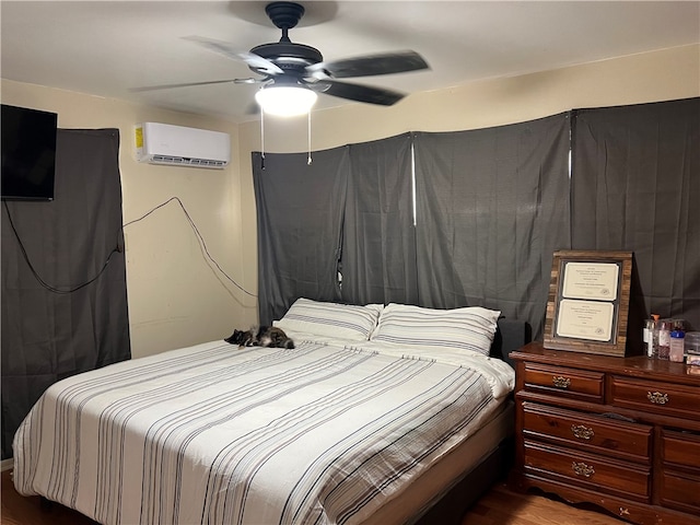 bedroom with a wall unit AC, wood-type flooring, and ceiling fan