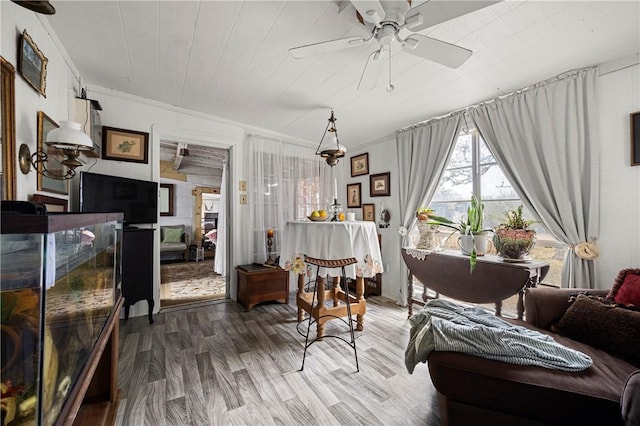 sitting room featuring ceiling fan, crown molding, and wood-type flooring