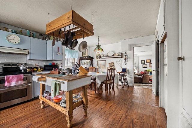 kitchen featuring a textured ceiling, range with two ovens, wood-type flooring, and backsplash