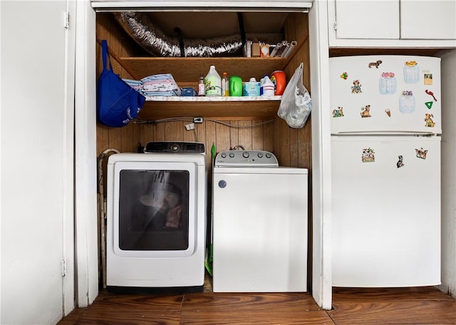 laundry area with washer and dryer and dark wood-type flooring