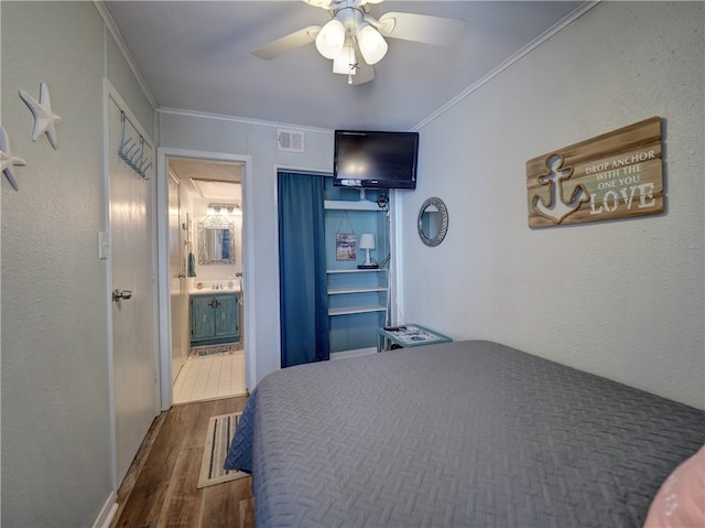 bedroom featuring dark wood-type flooring, ceiling fan, sink, and crown molding