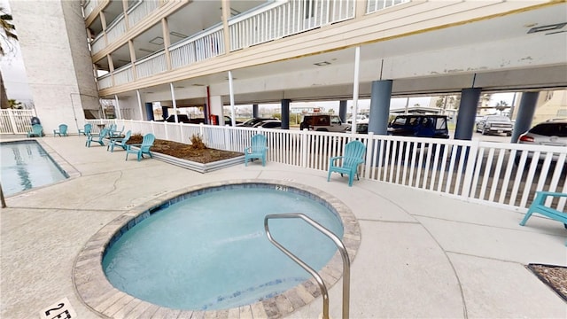 view of pool with a hot tub and a patio area