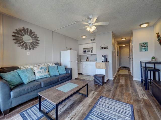 living room with a textured ceiling, dark hardwood / wood-style floors, and ceiling fan