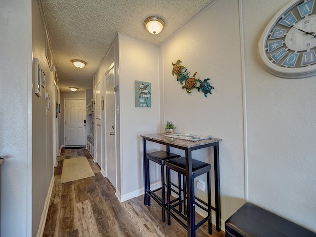 hallway with hardwood / wood-style flooring and a textured ceiling