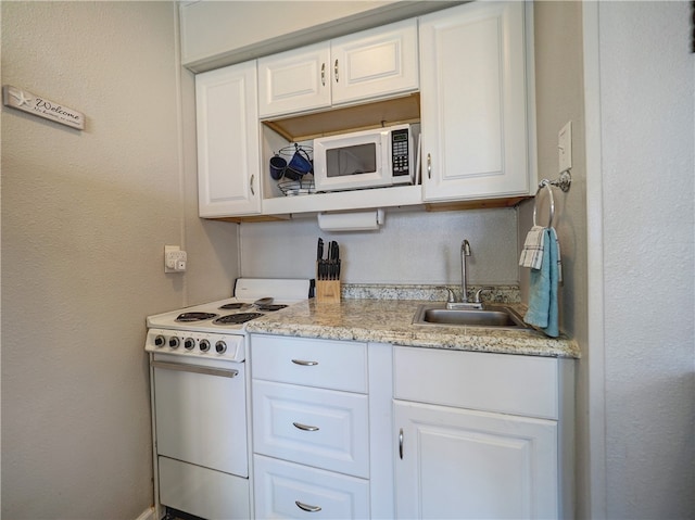 kitchen featuring white cabinetry, white appliances, and sink