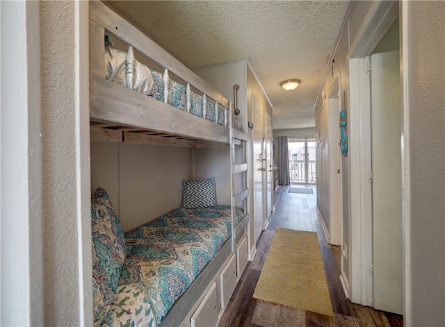 bedroom featuring dark wood-type flooring and a textured ceiling