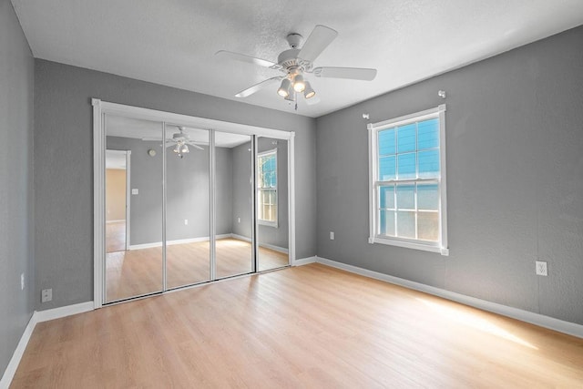 unfurnished bedroom featuring wood finished floors, a ceiling fan, and baseboards