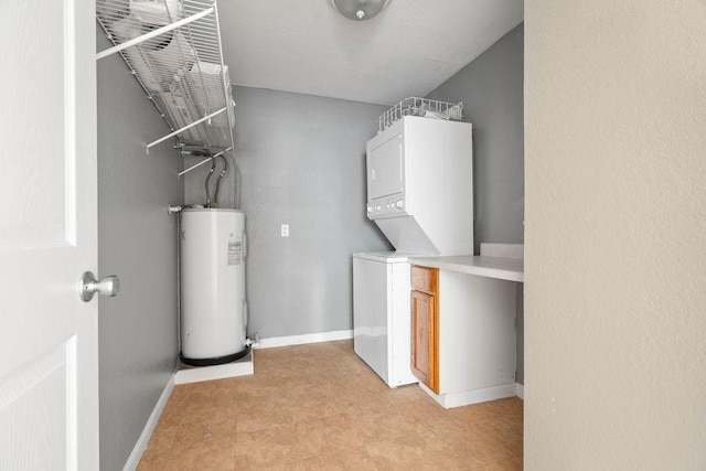 washroom with stacked washer / drying machine, laundry area, water heater, and baseboards