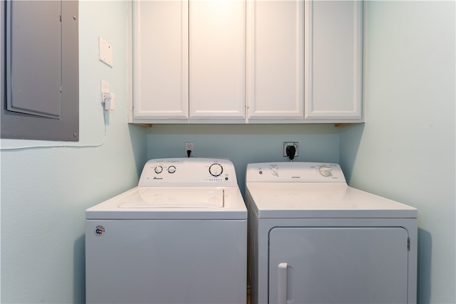 clothes washing area with electric panel, separate washer and dryer, and cabinets