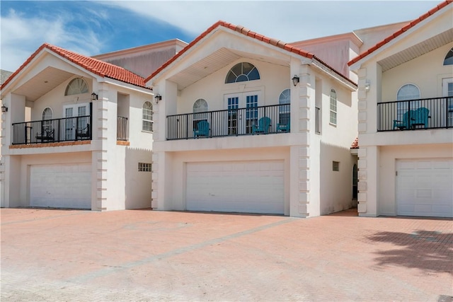 103 E Palmetto Dr Unit B, South Padre Island, TX 78597 - view of front of home featuring stucco siding, an attached garage, and french doors