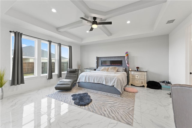 bedroom with ceiling fan and a raised ceiling