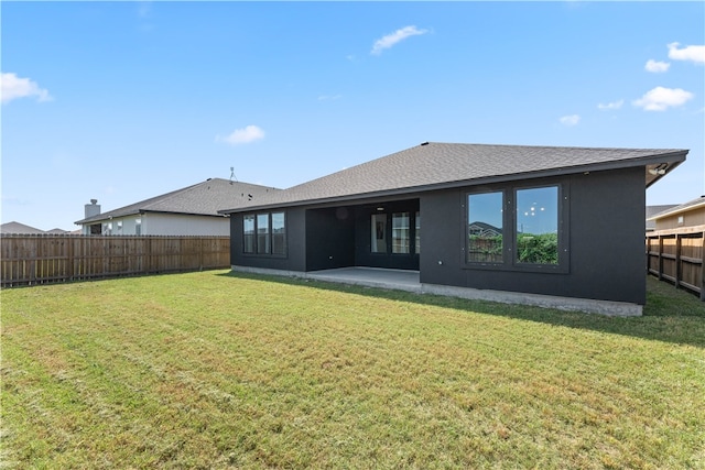 back of house featuring a patio and a yard