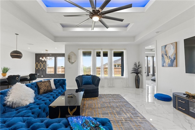 living room with plenty of natural light, ceiling fan, and a tray ceiling