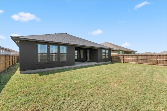 rear view of property featuring a patio and a lawn