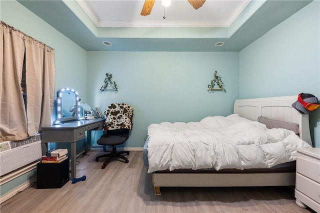 bedroom featuring a tray ceiling, ceiling fan, light hardwood / wood-style floors, and ornamental molding