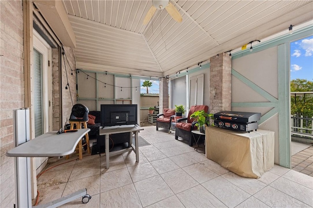 sunroom featuring ceiling fan and lofted ceiling