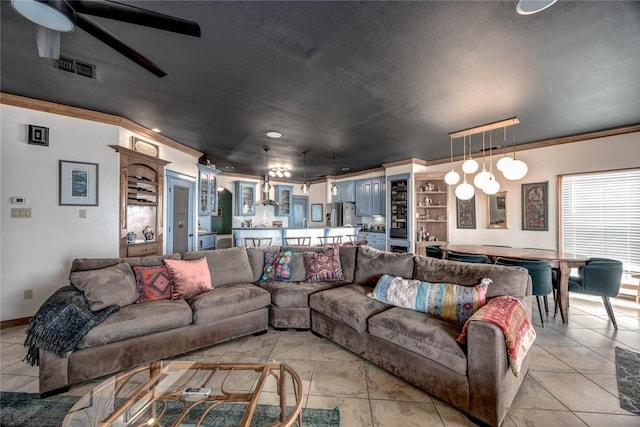 living room featuring ceiling fan, light tile patterned floors, and crown molding