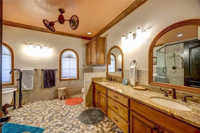 full bathroom featuring separate shower and tub, vanity, tile walls, toilet, and ornamental molding