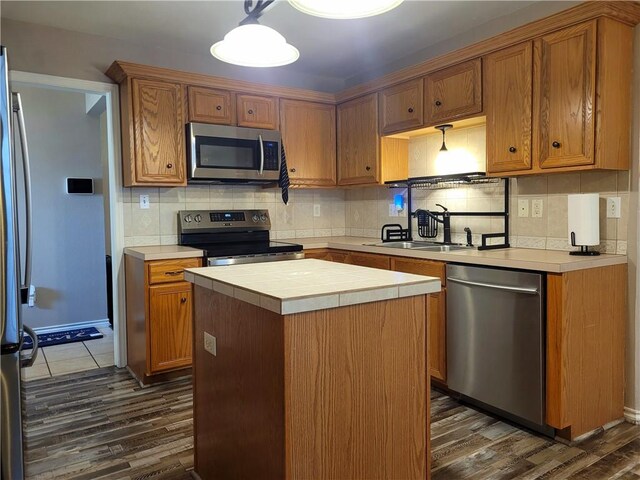 2022 Jenica Dr, Ingleside, TX 78362 - kitchen with stainless steel appliances, dark wood finished floors, tile countertops, backsplash, and a sink
