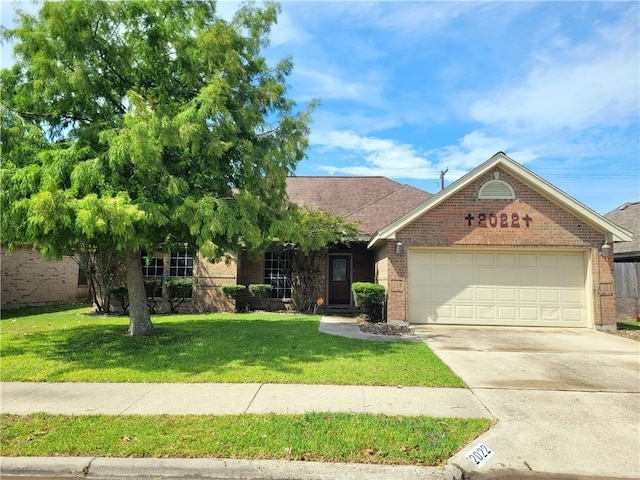 2022 Jenica Dr, Ingleside, TX 78362 - view of front of home with brick siding, an attached garage, a front yard, and concrete driveway