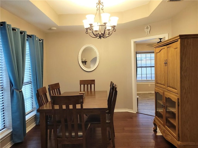 2022 Jenica Dr, Ingleside, TX 78362 - dining space featuring a chandelier, a raised ceiling, dark wood-type flooring, and baseboards