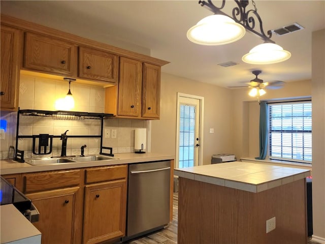 2022 Jenica Dr, Ingleside, TX 78362 - kitchen with dishwasher, a sink, backsplash, and brown cabinets