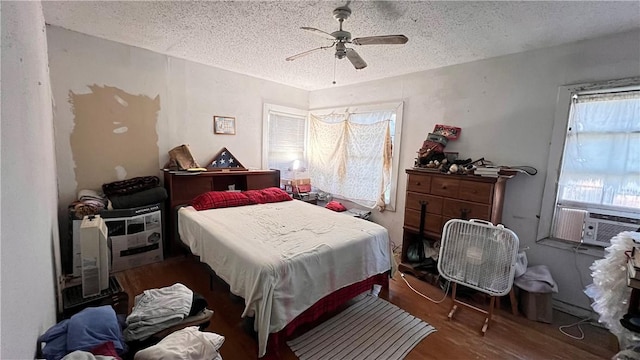 4049 Laguna Shrs, Corpus Christi, TX 78418 - bedroom featuring wood finished floors, a textured ceiling, cooling unit, and ceiling fan