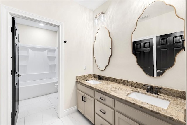 bathroom featuring a sink, baseboards, marble finish floor, and double vanity