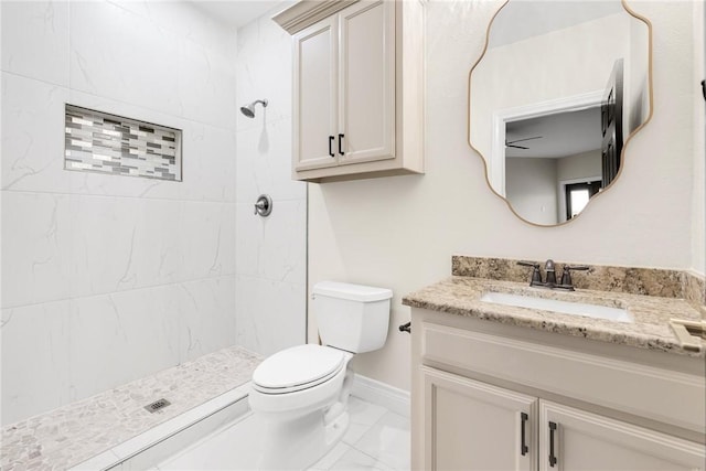 bathroom featuring vanity, toilet, marble finish floor, and a tile shower